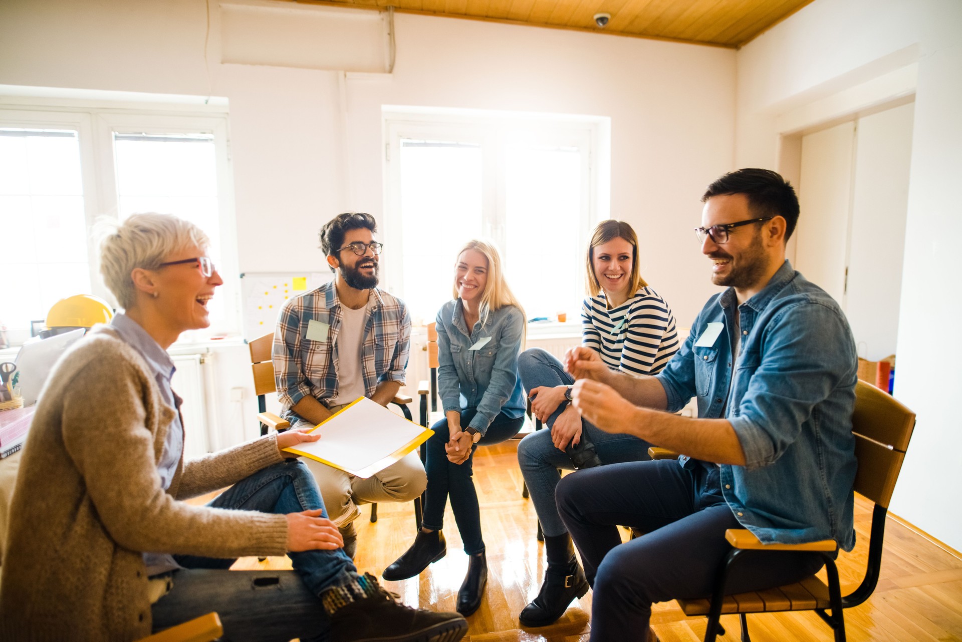 Group of people sitting in a circle on group therapy. One man is talking about his experience.
